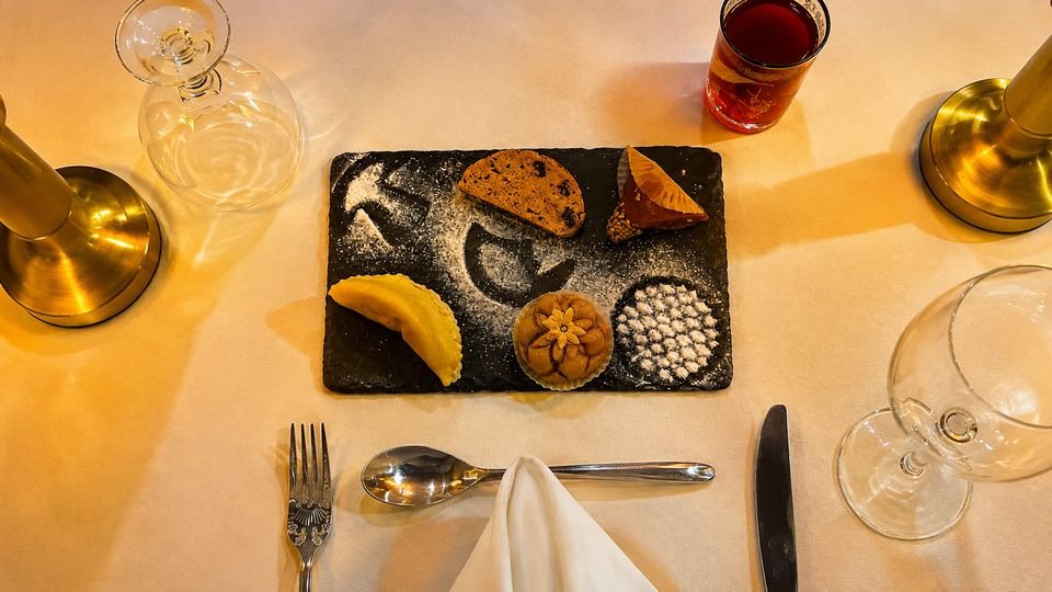 Small Moroccan pastries on a slate dusted with sugar, seen from above
